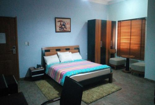 伊巴丹Room in Lodge - Wetland Hotels, Ibadan的蓝色客房中一间带床的卧室