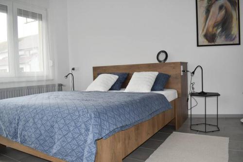 武科瓦尔Apartman WALKOW的一间卧室配有一张带蓝色和白色床单的床和窗户。