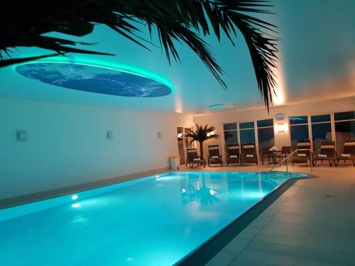 费马恩Avalon Hotel Bellevue的大楼内带蓝色灯光的游泳池