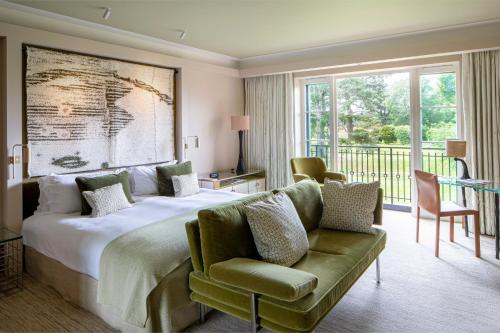 Chandler's Cross格鲁夫酒店的一间卧室配有一张大床和一张绿色沙发