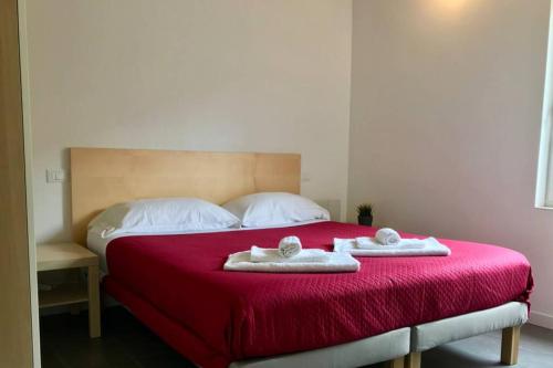 阿塞尔吉Rifugio del Gran Sasso的一间卧室配有红色的床和2条毛巾