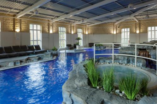 斯拉利Slaley Hall Hotel, Spa & Golf Resort的一座蓝色海水的大型室内游泳池