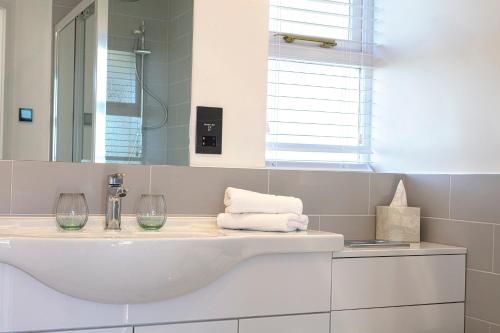 North FambridgeThe Ferry Boat Inn的白色的浴室设有水槽和镜子