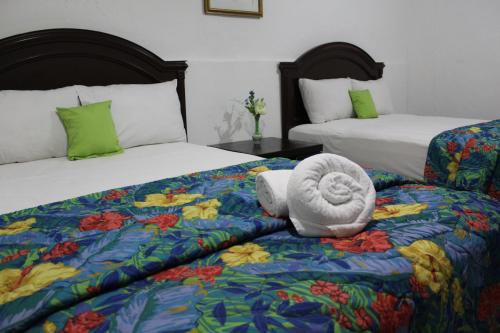 梅里达埃尔熙德酒店的酒店客房,配有两张床,床上配有毛巾