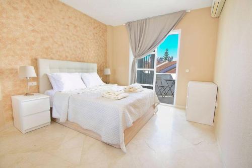 福恩吉罗拉Spectacular Apartment in Matchroom Country Club的卧室配有白色的床和窗户。