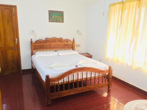 可瓦兰Ganesh House Ayurveda Homestay的一间卧室,卧室内配有一张木床