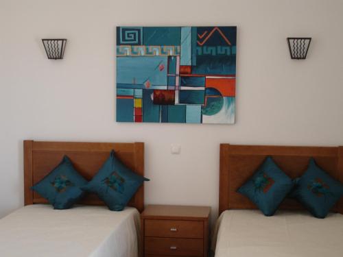 阿尔布费拉Apartamentos Atlantico by OA的墙上画画的房间里设有两张床