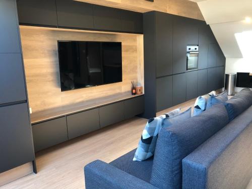拉布雷斯Ma Montagne Chic 2的客厅配有蓝色的沙发和平面电视。