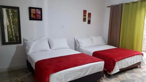卡利Moderno apartasuite con aire acondicionado的一间卧室配有两张红色和白色的床