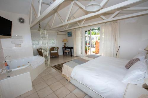 Gooseberry HillRosebridge House Bed & Breakfast Adult Retreat的一间卧室配有一张床、一个浴缸和一个水槽