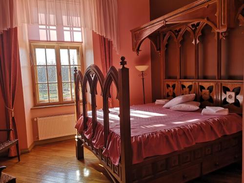 Dundaga敦达加比尔斯旅舍的一间卧室配有一张大木床和红色床单
