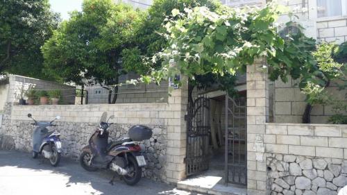 杜布罗夫尼克Apartment Wild Orange的两辆摩托车停在砖砌建筑旁边