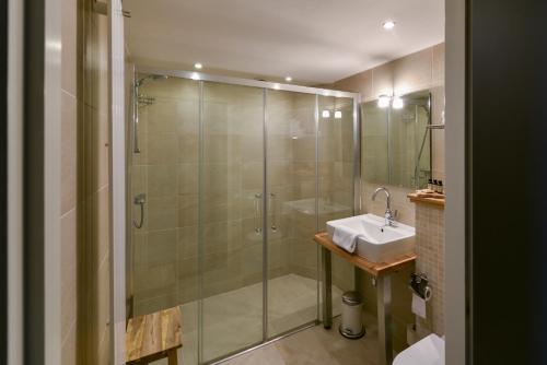 斯赫拉芬赞德格拉维酒店的一间带玻璃淋浴和水槽的浴室