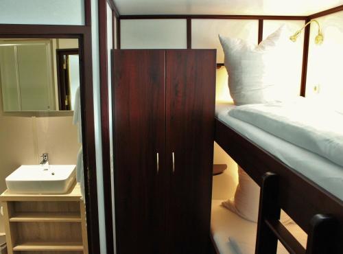 不莱梅Alexander von Humboldt - Das Schiff的一间卧室配有双层床和水槽