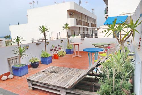 科尼尔-德拉弗龙特拉Habitación Cañaveral Playa Conil II的阳台配有桌子和盆栽植物