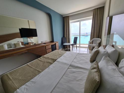 比尔泽布贾Water's Edge Hotel的酒店客房设有一张大床,享有海景。