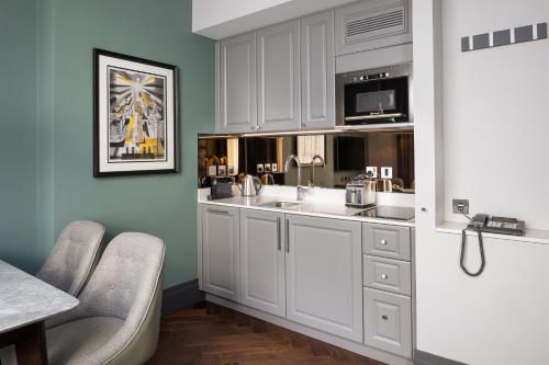 伦敦Hapimag Apartments London的厨房配有白色橱柜和水槽