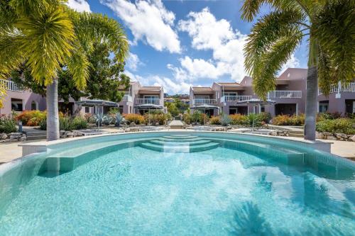 威利布罗德Coral Estate Luxury Resort的一座楼前棕榈树游泳池