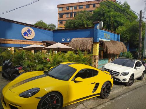 麦德林Yolo Hostel Medellin的停在一辆白色汽车旁边的黄色汽车