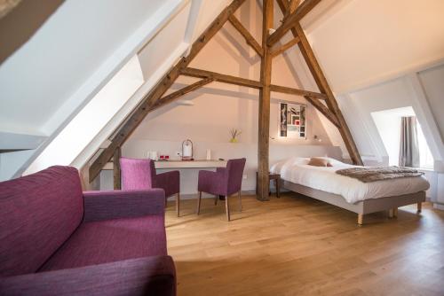 阿列河畔美岸Château du Bost - Teritoria的卧室配有一张床和一张桌子及椅子