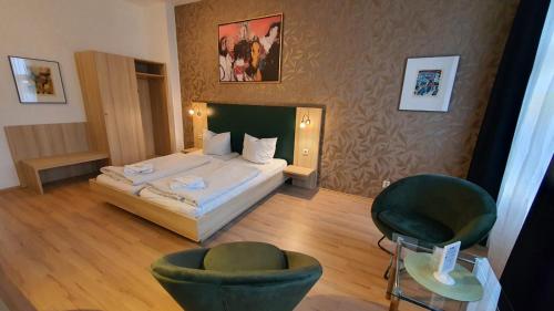 柏林伯恩霍尔默霍夫普伦茨劳贝格酒店的一间卧室配有一张床和两张绿色椅子