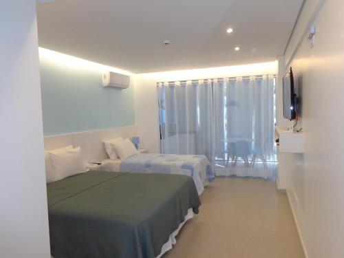 巴西利亚HOTEL GARVEY Quarto 321的酒店客房设有两张床和电视。