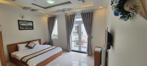 大叻Peony Hotel的一间卧室设有一张床和一个大窗户