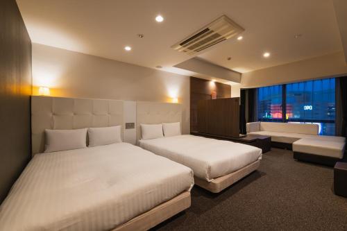 福冈HOTEL THE HAKATA TERRACE的酒店客房,设有两张床和一张沙发