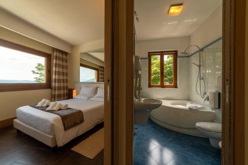 阿罗纳圣卡洛餐厅酒店的一间卧室配有一张床、一个浴缸和一个水槽