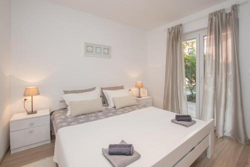 乌马格Apartments Lirio的白色的卧室设有一张大床和一个窗户
