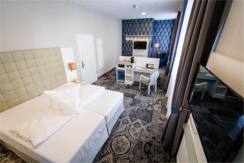 萨勒河畔巴特诺伊施塔特拜德纽斯塔德特城堡酒店的卧室配有白色的床和书桌