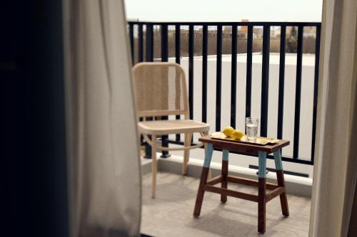 马公日光事务所的阳台配有椅子和一张桌子,上面装有玻璃杯