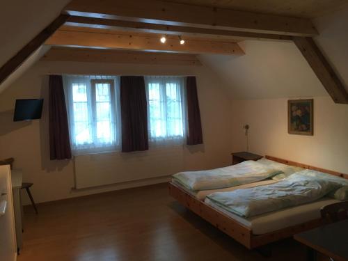 EscholzmattHotel Löwen的一间卧室设有两张床和两个窗户。