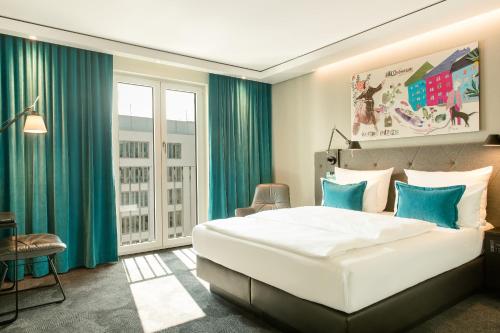 慕尼黑Motel One München-Haidhausen的卧室配有白色大床和蓝色窗帘