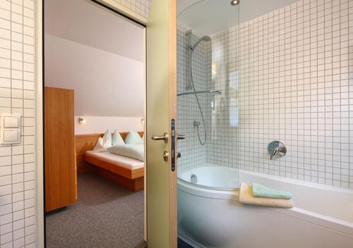 奥伯古格尔博赛公寓酒店的一间带浴缸和淋浴的浴室以及一张床