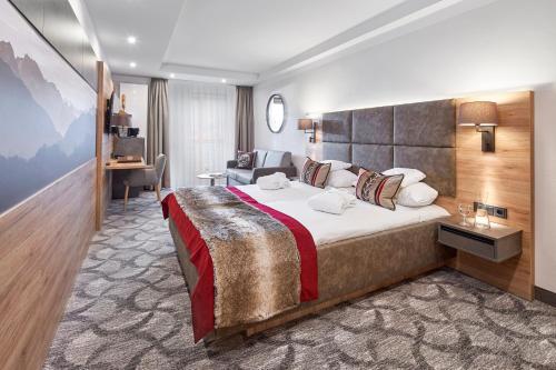 巴特维塞Hotel Alpenhof的酒店客房设有一张大床和一张书桌。