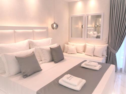 帕拉塔蒙Amaryllis Luxury Rooms的白色客房,床上配有白色枕头