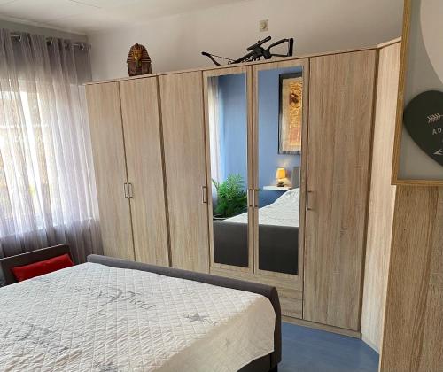 布鲁日咪咪出租民宿的一间卧室配有一张床和一面大镜子