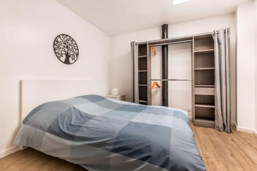 图尔昆Le ZEN... appartement avec fauteuil massant!的卧室配有一张床,墙上挂着一个钟