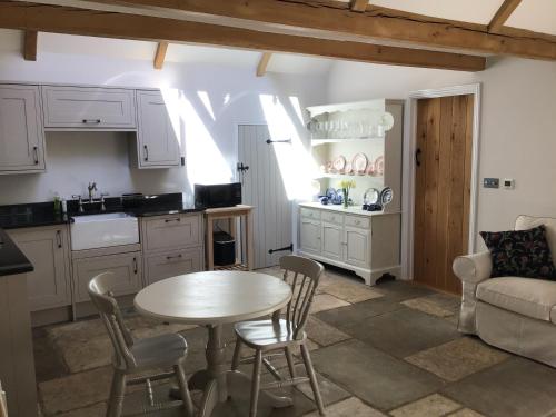 斯特劳德Courtyard Cottage的厨房以及带桌椅的起居室。