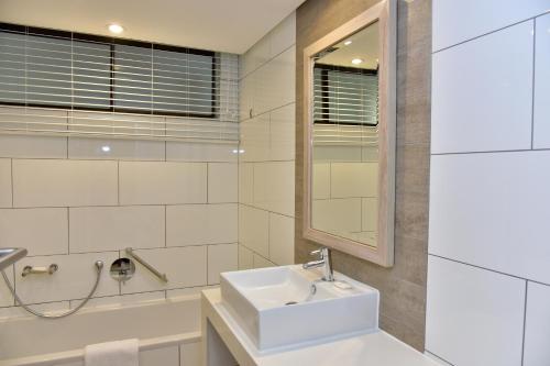 德班La Lucia Sands Beach Resort的白色的浴室设有水槽和镜子