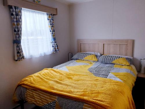 海斯廷斯The Abi Joseph @Combe Haven的一间卧室配有一张黄色毯子床