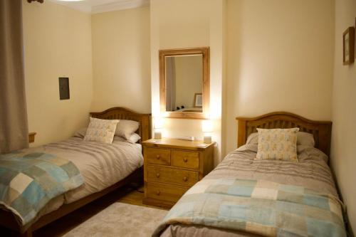 爱丁堡Newly Refurbed Home with Free Parking的一间卧室配有两张床和镜子