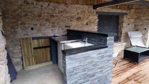 BaronGîtelabaronnaise avec piscine chauffée prés parc Asterix的一间带水槽和石墙的浴室