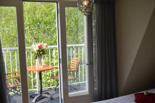 阿姆斯特丹阿尔卑斯山酒店的一间设有一扇门的客房,可通往带桌子的阳台