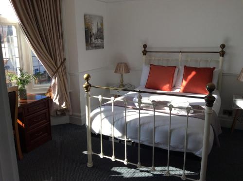 亨斯坦顿加布勒斯酒店的一间卧室配有一张带红色枕头的床和一扇窗户