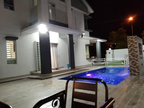 汝来Villa with private Pool and Sauna @ Nilai的一座晚上设有游泳池的房子
