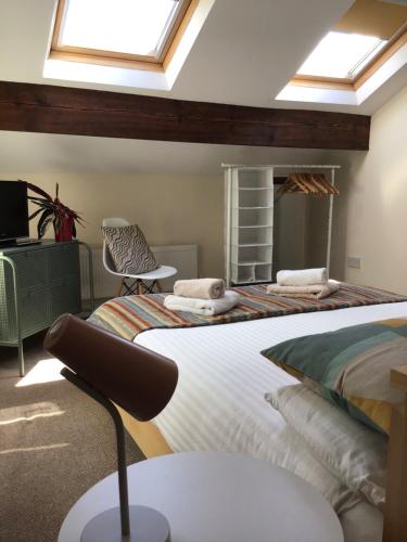哈罗盖特孔弗伦斯家庭式旅馆的一间卧室设有两张床、一台电视和天窗。