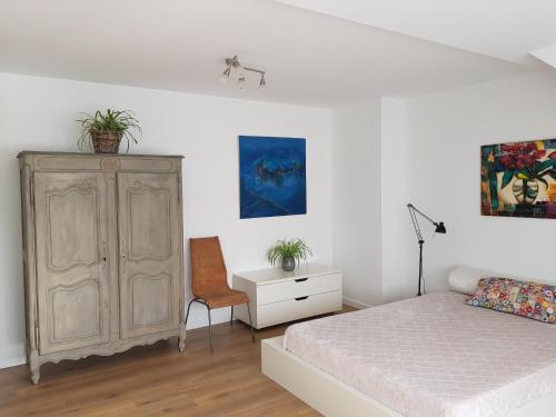 布鲁塞尔MAISON DES FLEURS的一间卧室配有一张床、一个橱柜和一把椅子