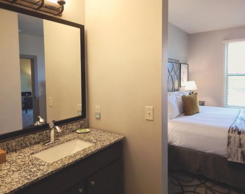 HuntWorldMark Hunt – Stablewood Springs Resort的一间带水槽的浴室和一张带镜子的床